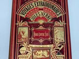 an old book with a red cover and gold lettering on it