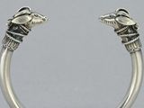 pair of silver cuff bracelets with eagle heads on each side