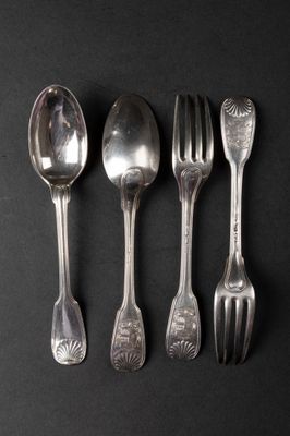 four silver spoons and two silver forks on a black surface