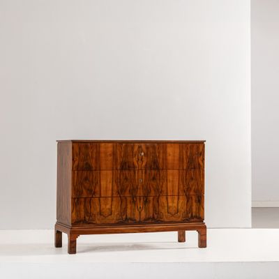 une photo d'une commode en bois dans une pièce blanche