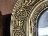 two ornate gold frames on the wall next to each other