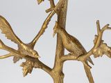 two birds perched on a branch of a tree on a table
