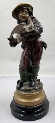 statue représentant un homme tenant un oiseau, posée sur un socle en bois