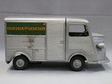 un petit camion jouet argenté avec une pancarte verte sur le côté
