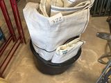 une pile de sacs posée par terre à côté d'une machine à laver