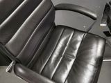 a black leather office chair with a glass top table