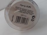 the lid of a jar of makeup on a white surface