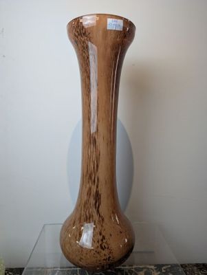 a brown vase sitting on top of a glass table