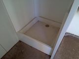 a white shower with a shower head in a bathroom