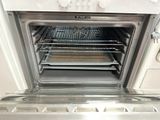 an open oven with baking trays inside of it