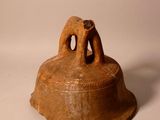a brown bell with two elephants on it