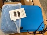 a blue laptop computer sitting on top of a cardboard box