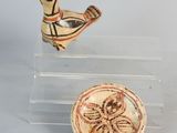three pieces of pottery sitting on top of a clear display case