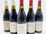 six bouteilles de vin rouge sont alignées
