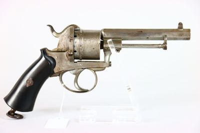 un vieux revolver avec une crosse noire sur fond blanc