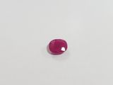 a pink sapphire stone on a white surface