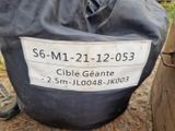a bag of cement sitting on the ground next to a wooden pole