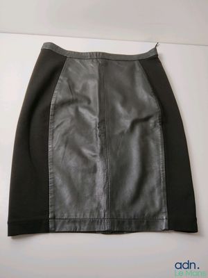 une jupe en cuir noir et gris accrochée à un mur