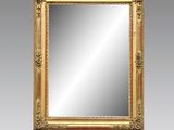a gold framed mirror on a grey wall