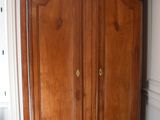 a large wooden armoire in the corner of a room