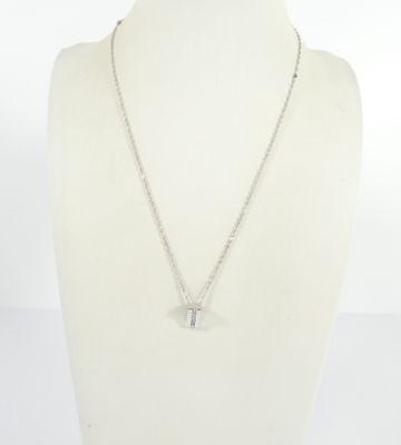 un collier avec un mannequin blanc orné d'une croix