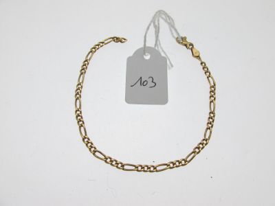 Gros plan sur un bracelet en chaîne en or portant une étiquette