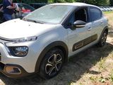 une petite voiture blanche garée sur l'herbe, dans le champ