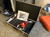 une valise contenant des outils, posée par terre