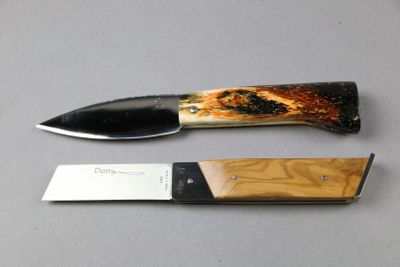 a knife that is laying next to a knife on a table