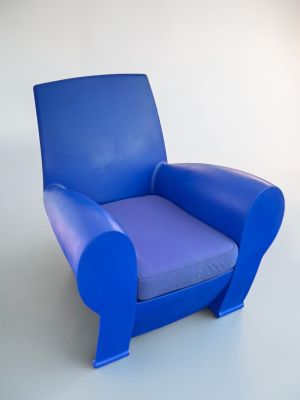 a blue chair that is sitting on a white floor