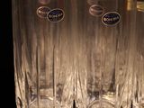 four glasses are lined up in a row on a black surface