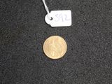 a small coin that is on the ground next to a price tag