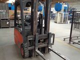 a forklift in a warehouse with a lot of equipment
