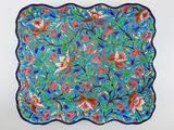 une image représentant une assiette bleue ornée de fleurs et de feuilles colorées