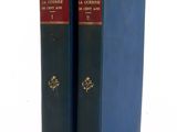 two blue books sitting on top of each other on top of a table