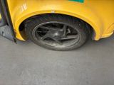 a close up of a yellow car with a flat tire