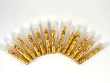 a close up of a bunch of gold glitter sticks on a white surface