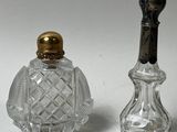 deux petites bouteilles en verre avec un bouchon doré et une bouteille en verre avec un bouchon noir