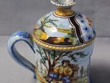 a blue and white cup with a lid and a picture on it