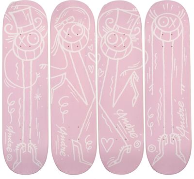 quatre skateboards roses ornés de dessins blancs sont alignés sur un fond blanc