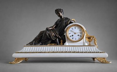 une statue représentant une femme assise sur un banc, avec une horloge devant elle