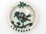 a plate with a bird on it on a white surface