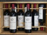 Des bouteilles de vin rouge sont alignées dans un casier à vin en bois