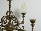 a chandelier with a glass shade hanging from it
