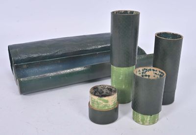 three rolls of black and green paper on a white surface