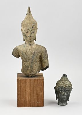 deux statues de Bouddha et une tête de Bouddha posées sur un socle en bois