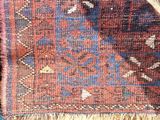 a close up of a red and blue area rug with fringes