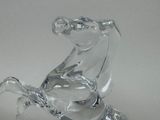 a glass horse figurine sitting on a white surface