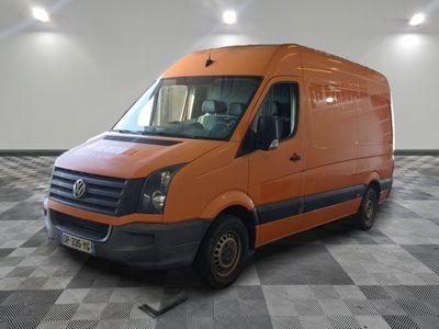 Une camionnette orange est garée dans une pièce au sol carrelé en damier.
