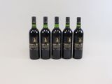 four bottles of wine are lined up on a white surface